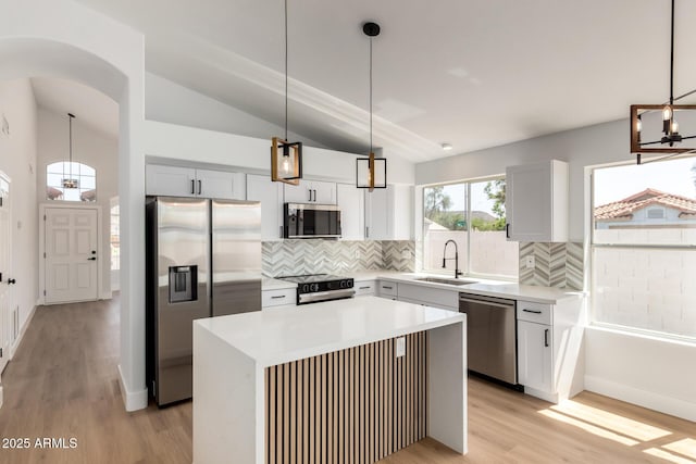 5125 W Wickiup Ln, Glendale, AZ 85308 - kitchen featuring appliances with stainless steel finishes, a sink, vaulted ceiling, backsplash, and light wood-style flooring