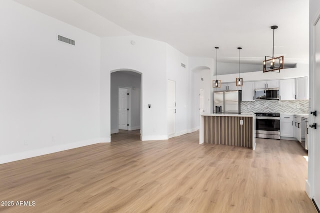 5125 W Wickiup Ln, Glendale, AZ 85308 - kitchen featuring stainless steel appliances, lofted ceiling, open floor plan, decorative backsplash, and arched walkways