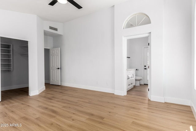 5125 W Wickiup Ln, Glendale, AZ 85308 - unfurnished bedroom with a towering ceiling, light wood-style floors, a walk in closet, baseboards, and ensuite bath