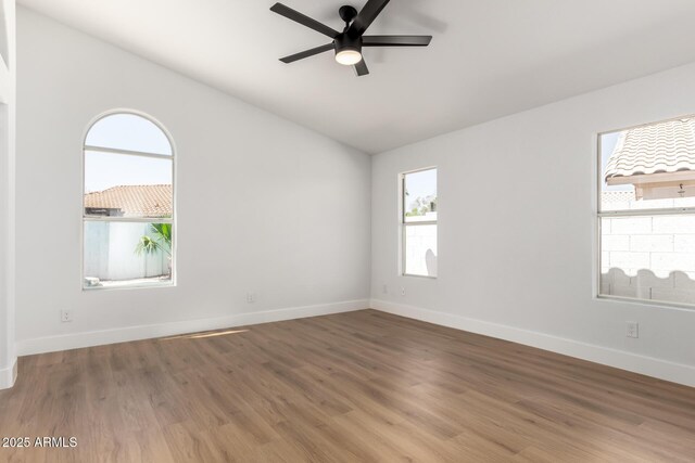 5125 W Wickiup Ln, Glendale, AZ 85308 - spare room featuring plenty of natural light, ceiling fan, baseboards, wood finished floors, and lofted ceiling