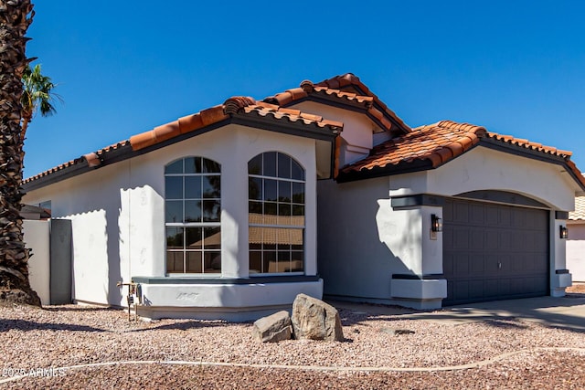 5125 W Wickiup Ln, Glendale, AZ 85308 - mediterranean / spanish-style house featuring a tiled roof, an attached garage, stucco siding, and concrete driveway