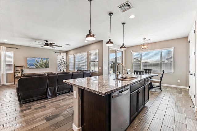 kitchen with a center island with sink, visible vents, wood tiled floor, a sink, and dishwasher