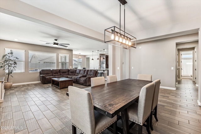 dining space featuring wood tiled floor, ceiling fan, and baseboards