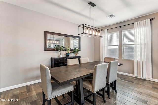 dining room featuring visible vents, baseboards, and wood finished floors