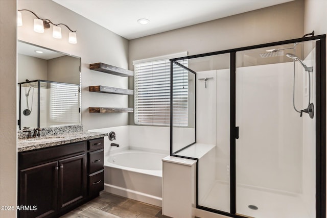 full bathroom featuring a stall shower, vanity, and a bath