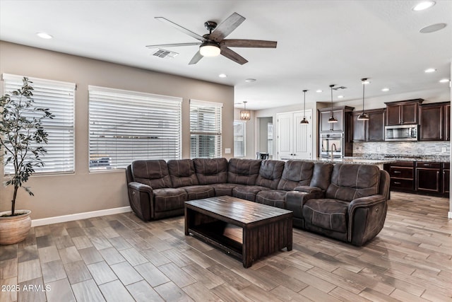 living area with baseboards, visible vents, ceiling fan, light wood-type flooring, and recessed lighting