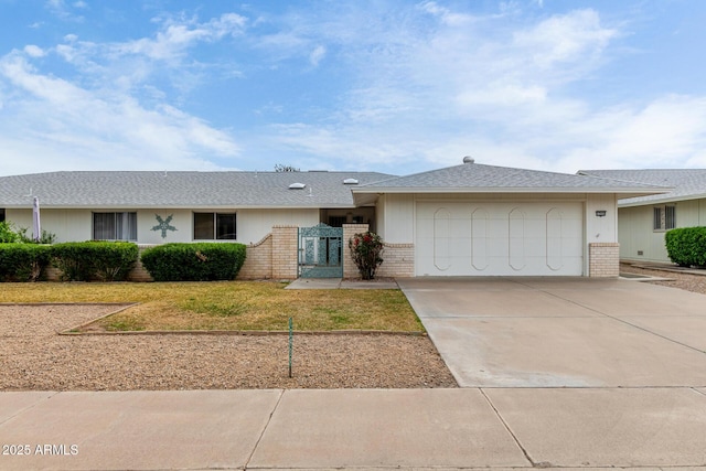 ranch-style home with a garage, a front yard, brick siding, and driveway