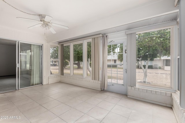 unfurnished sunroom featuring ceiling fan