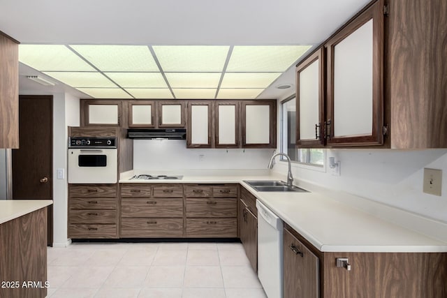 kitchen with white appliances, light tile patterned floors, a sink, extractor fan, and light countertops