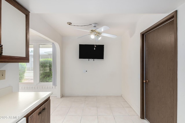 interior space featuring light countertops, light tile patterned floors, baseboards, and ceiling fan