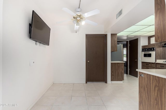 kitchen featuring oven, visible vents, a ceiling fan, and light countertops