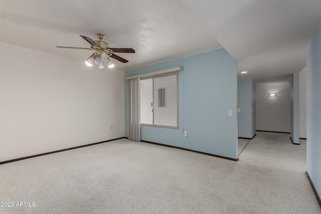 empty room with ceiling fan, baseboards, and light carpet