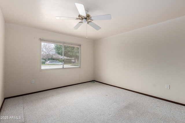 empty room featuring a ceiling fan, carpet, and baseboards