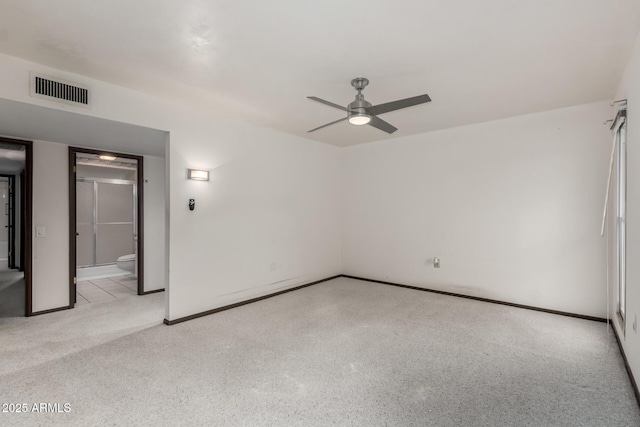 spare room featuring a ceiling fan, visible vents, and baseboards