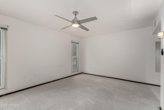 unfurnished room with a ceiling fan and baseboards