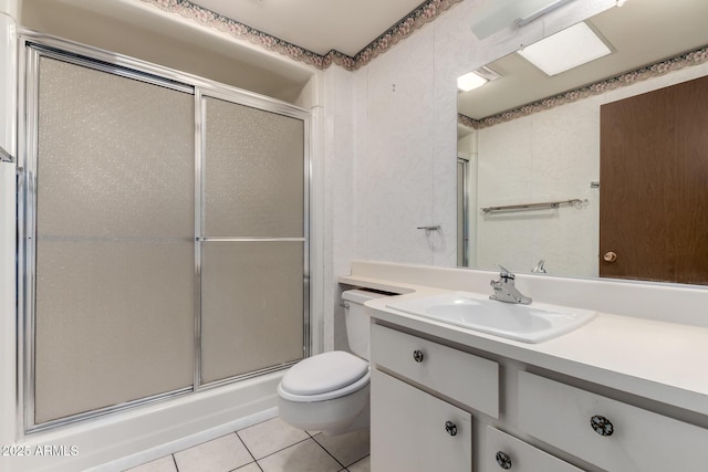 full bath featuring tile patterned floors, toilet, vanity, and a shower with shower door