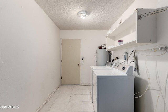 laundry area with light tile patterned floors, laundry area, water heater, a textured ceiling, and washer and dryer