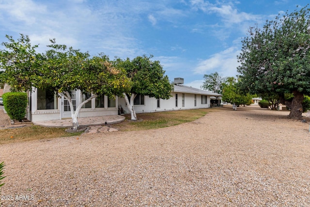 back of house with driveway and a sunroom