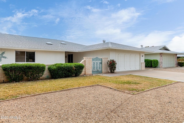 ranch-style house with a shingled roof, concrete driveway, a front lawn, a garage, and brick siding