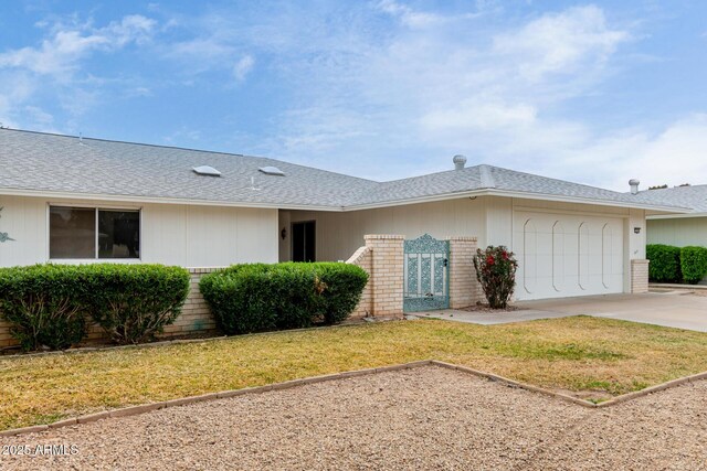 single story home with roof with shingles, concrete driveway, a front yard, a garage, and brick siding