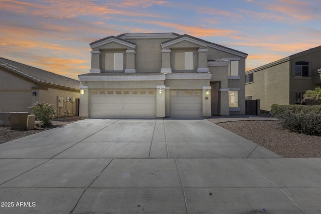 view of front of property with driveway, an attached garage, and stucco siding