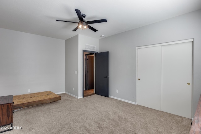 unfurnished bedroom with a ceiling fan, a closet, carpet flooring, and visible vents