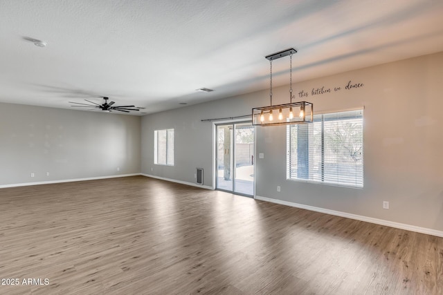 spare room with visible vents, baseboards, and wood finished floors