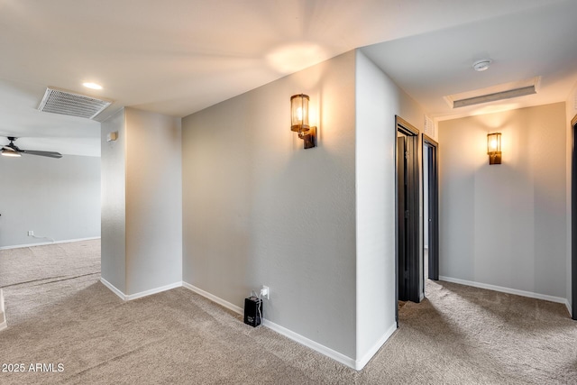 hall with baseboards, visible vents, and carpet flooring