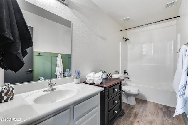 full bathroom featuring bathing tub / shower combination, visible vents, toilet, vanity, and wood finished floors