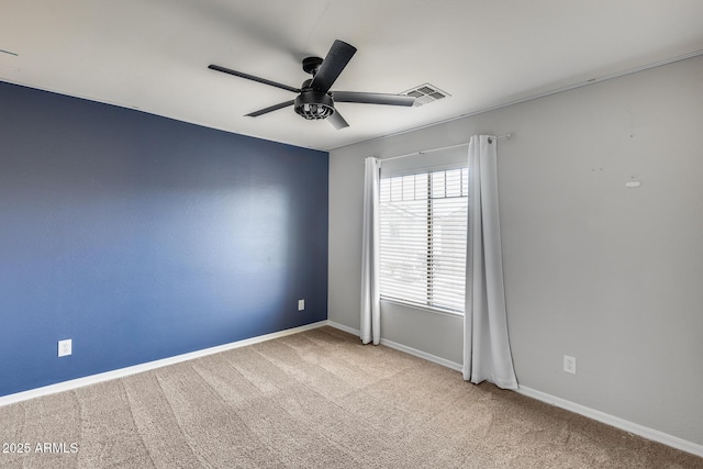 empty room featuring ceiling fan, carpet, visible vents, and baseboards