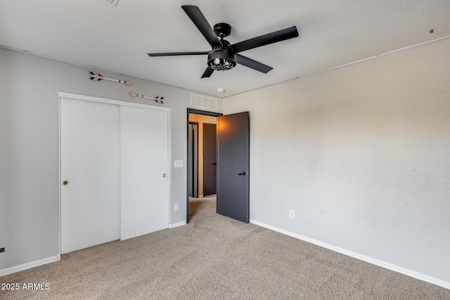 unfurnished bedroom with ceiling fan, light carpet, visible vents, baseboards, and a closet