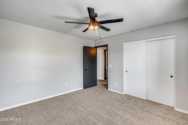 unfurnished bedroom featuring baseboards, visible vents, ceiling fan, carpet, and a closet