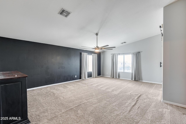 unfurnished room featuring ceiling fan, lofted ceiling, carpet flooring, visible vents, and baseboards