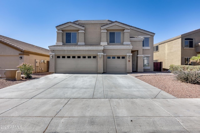 view of front facade with a garage, driveway, and stucco siding