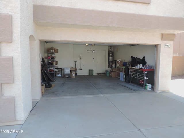 garage featuring water heater and driveway