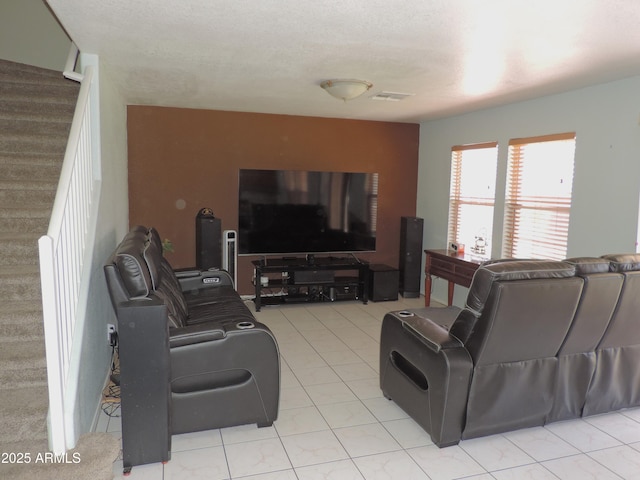 living room with visible vents, light tile patterned flooring, and stairs