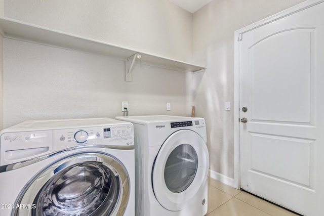 laundry room featuring washing machine and clothes dryer and light tile patterned flooring