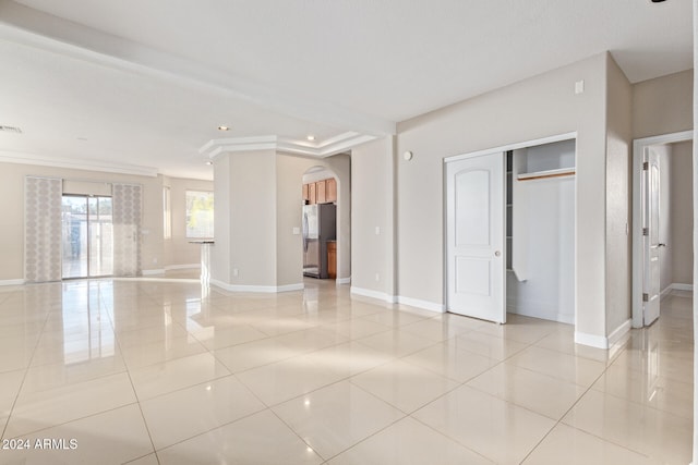 unfurnished bedroom featuring stainless steel fridge, light tile patterned floors, and ornamental molding