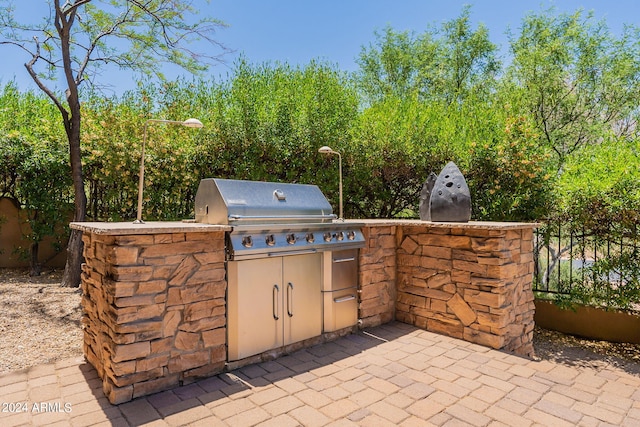 view of patio / terrace featuring exterior kitchen and a grill