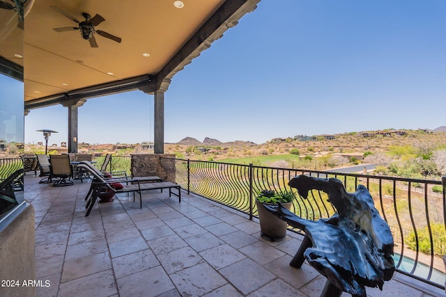 view of patio / terrace with a balcony, a mountain view, and ceiling fan