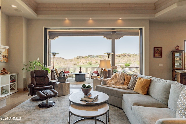 living room with a tray ceiling and tile patterned floors