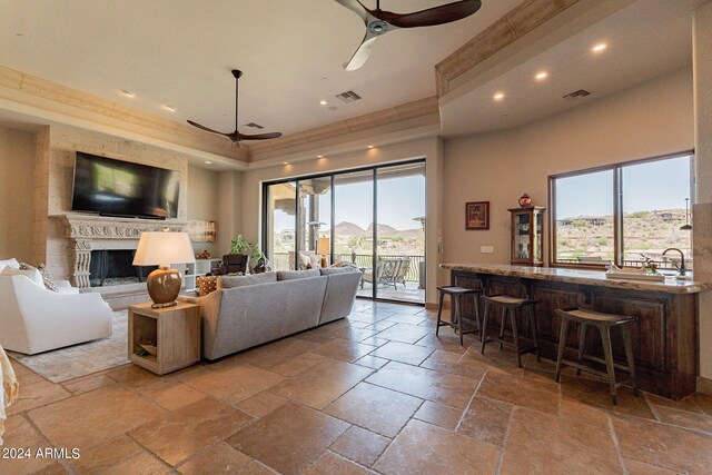 living room with a tray ceiling, ceiling fan, and plenty of natural light