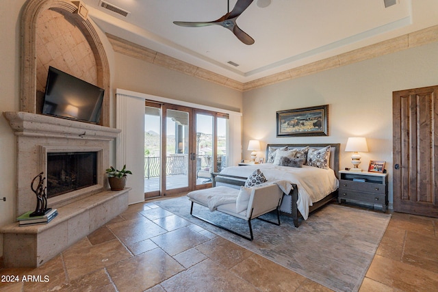 bedroom featuring ceiling fan, a raised ceiling, french doors, and access to exterior