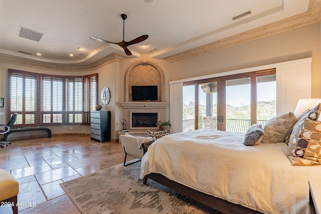 bedroom with access to exterior, ornamental molding, a large fireplace, ceiling fan, and french doors