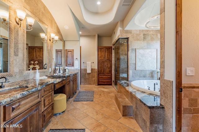 bathroom with vanity, tile walls, and shower with separate bathtub