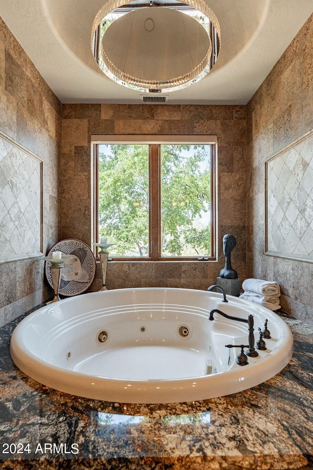 bathroom with tile walls and a relaxing tiled tub