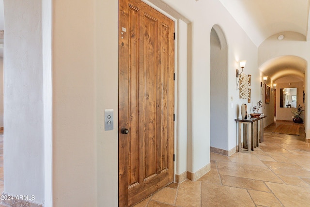 hall featuring lofted ceiling