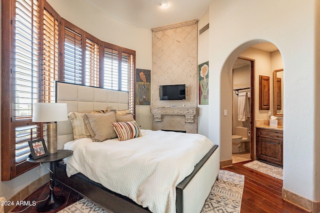 bedroom featuring dark hardwood / wood-style flooring and ensuite bathroom