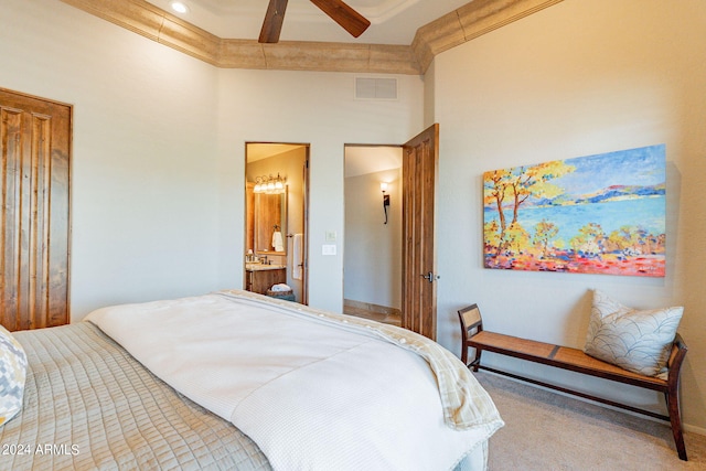 carpeted bedroom with beam ceiling, ensuite bath, ceiling fan, and ornamental molding