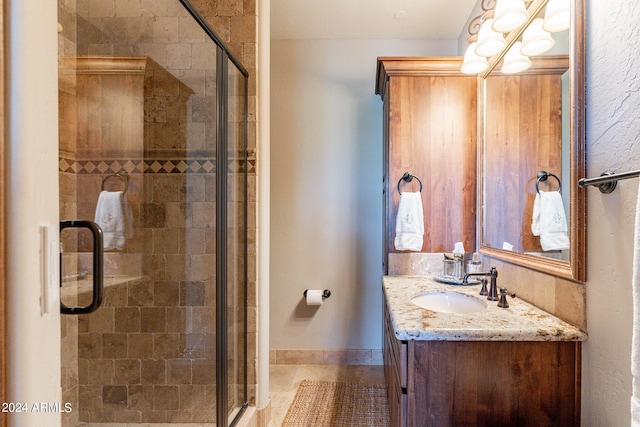 bathroom featuring tile patterned floors, an enclosed shower, and vanity